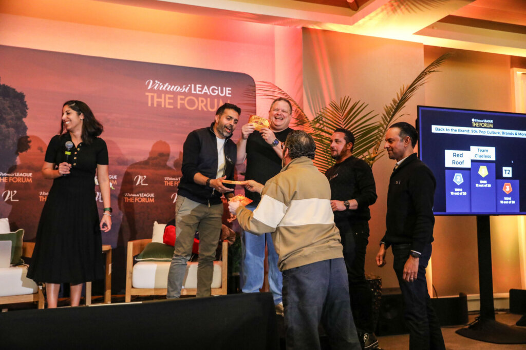 A group of CMO's and Senior marketing leaders celebrate at a podium after winning a kahoot.